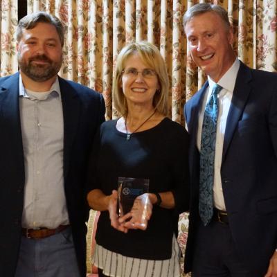 Victoria Romanda, chief of staff for Peg's Foundation, center, accepts the Foundation Donor of the Year Award from board member Aaron Kurchev, left, and CSS CEO Bob Stokes.
