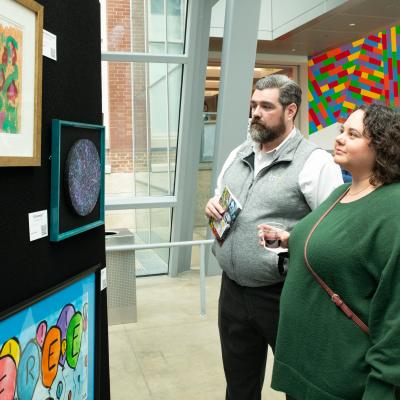 A man and woman view art at Art of Recovery.