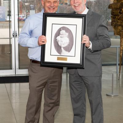 A man from GPD Group accepts framed artwork from CSS' Michael Gaffney.