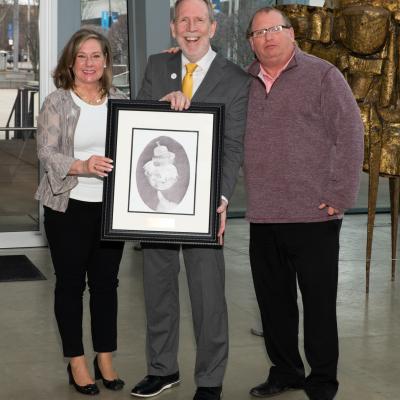 Representatives from the Reymann Foundation accept their sponsor gift of a framed drawing.