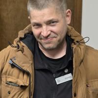 A photo of Stanley in a tan jacket and black shirt