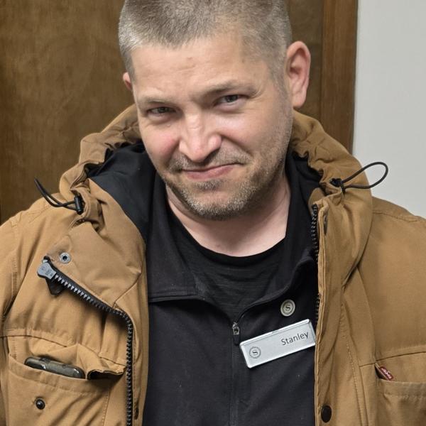 A photo of Stanley in a tan jacket and black shirt